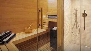 Een sauna met houten banken, een houten emmer en een zwarte prullenbak.