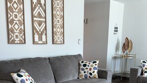 A grey sofa with patterned cushions, a geometric rug, and decorative wall art. - Close to Sedona, Cottonwood, Wineries & Jerome (Cottonwood)