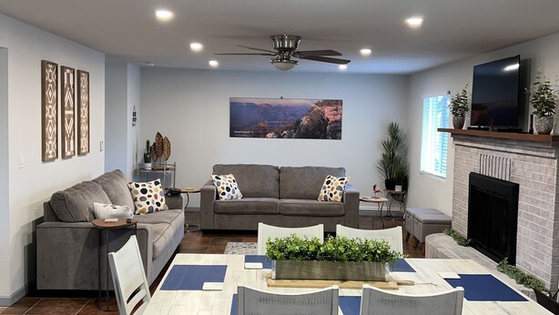 A modern living room with a dining area, grey sofas, a flat-screen TV, and a fireplace. - Close to Sedona, Cottonwood, Wineries & Jerome (Cottonwood)