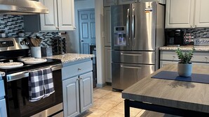 A modern kitchen with light blue cabinets, stainless steel appliances, and a tiled backsplash. - Close to Sedona, Cottonwood, Wineries & Jerome (Cottonwood)