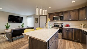 A modern kitchen with wooden cabinets, a marble countertop, and stainless steel appliances. - Lovely 3 bedroom Apartment in Bozeman! Unit #C  (Bozeman)