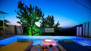 Ein Poolbereich mit Liegestühlen aus Holz, einem Poolspielzeug und einem Tisch mit Getränken und Snacks. Ein Schild zeigt 'Villa Sepeti'.