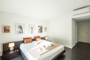 A hotel room with a bed, bedside tables, a nightstand, and wall-mounted artwork. - Elegant villa with infinity heatable pool (Alvor)