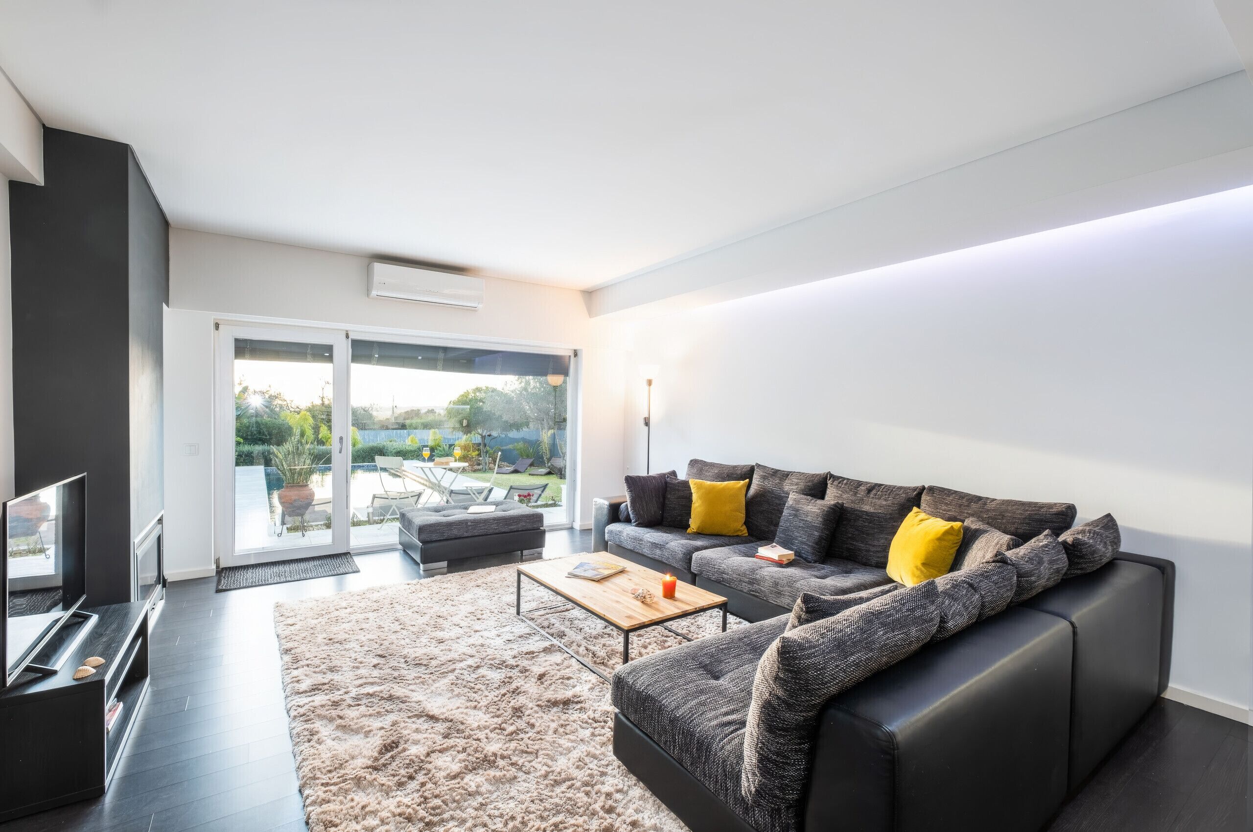 Ein modernes Wohnzimmer mit Sofa, Couchtisch und Flachbildfernseher.