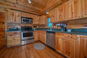 Una cocina moderna con armarios de madera, electrodomésticos de acero inoxidable y encimera verde.