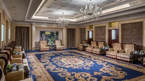 A formal meeting room with a large blue carpet, ornate chairs, a chandelier, and a painting on the wall. - Holiday Inn Hotel & Sts Wuhan International Expo (Wuhan)