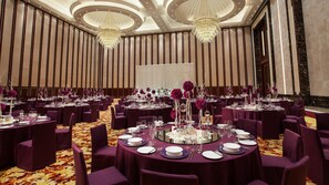 A banquet hall with round tables, purple tablecloths, and chandeliers. - Holiday Inn Hotel & Sts Wuhan International Expo (Wuhan)