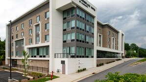 A modern hotel building with a flat roof, large windows, and a sign indicating it is a Marriott hotel. - TownePlace Suites by Marriott Asheville Downtown (Asheville)