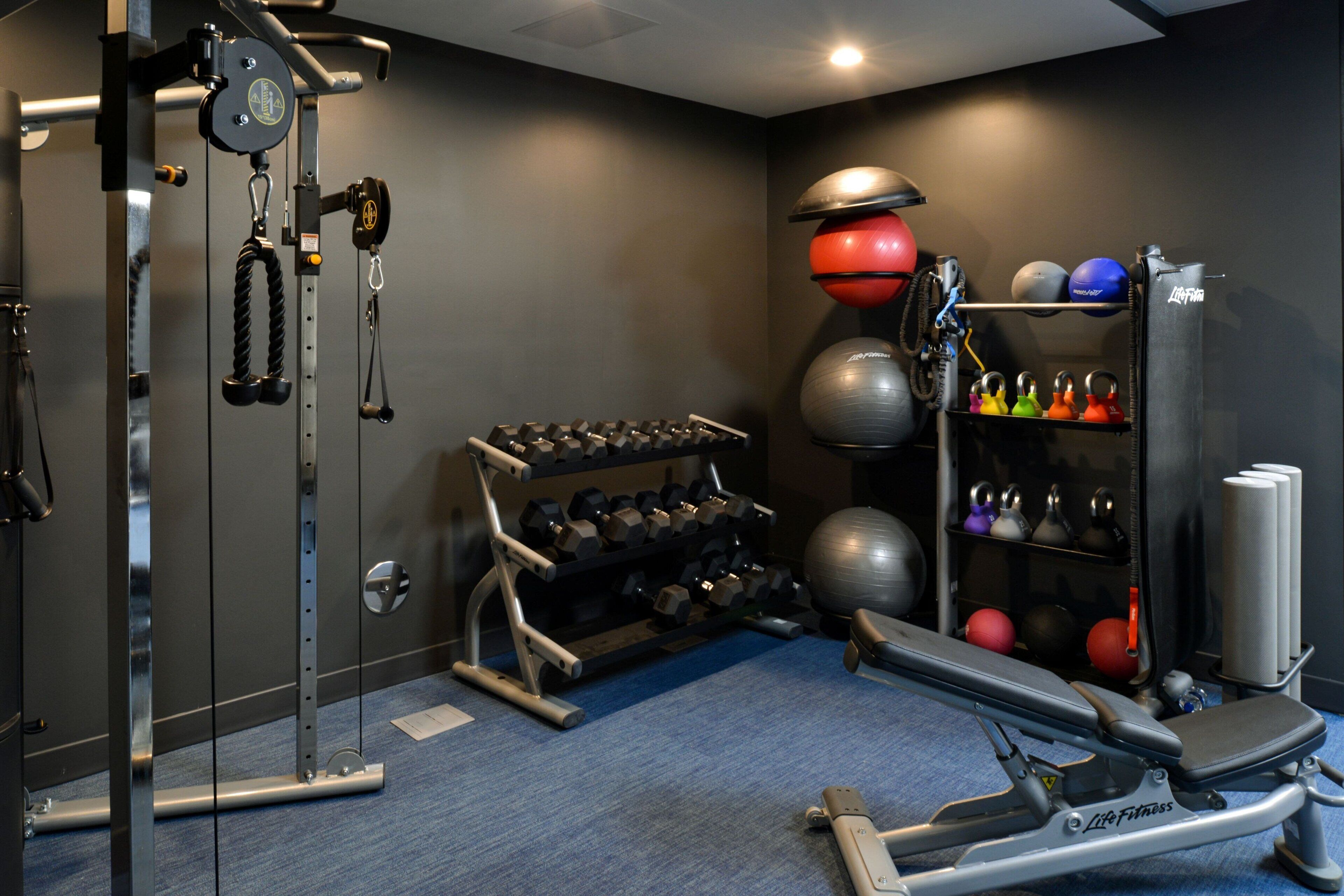 Ein Fitnessstudio mit Gewichten, Übungsbällen und Kurzhanteln.