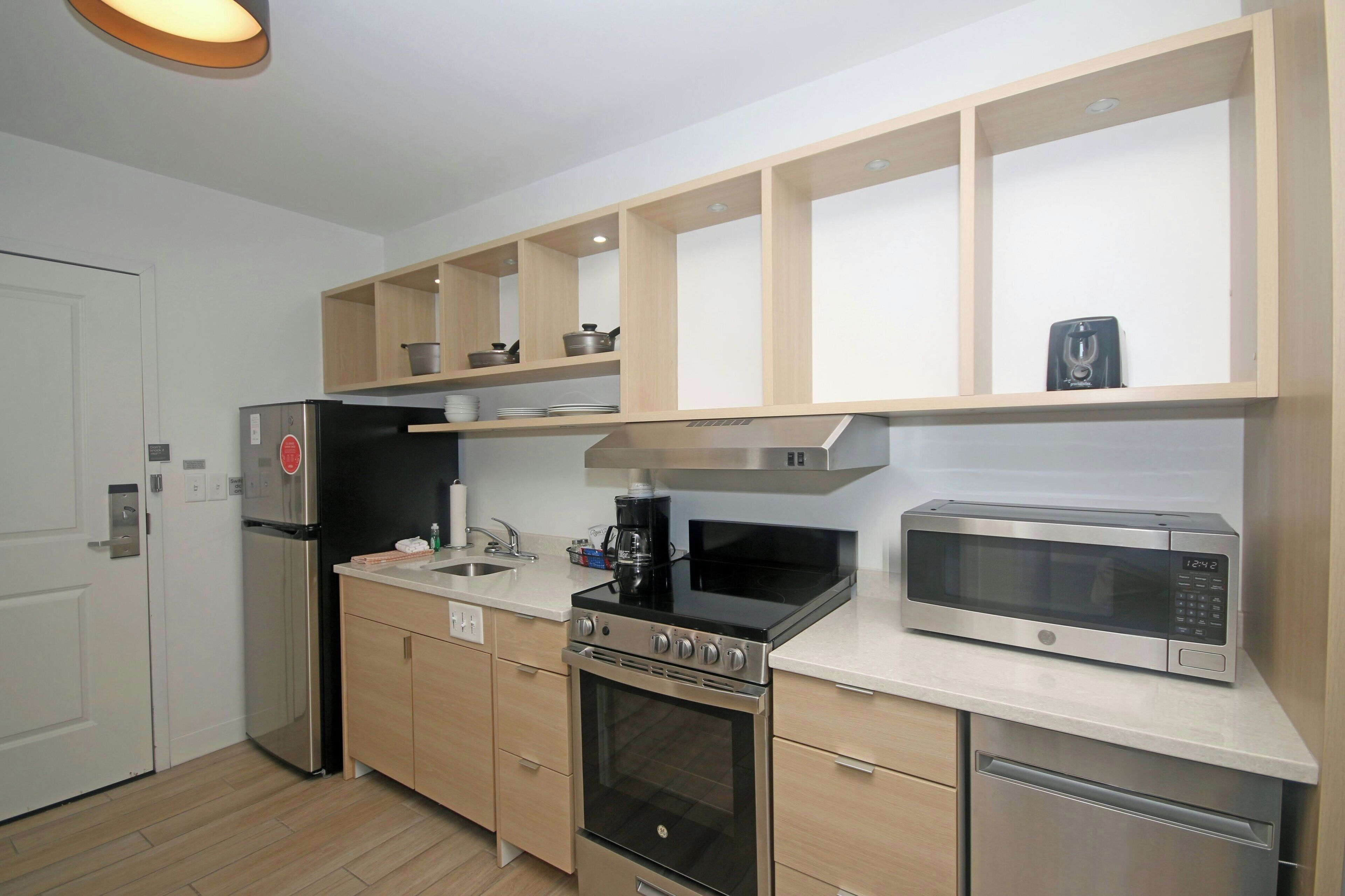 Una cucina moderna con elettrodomestici in acciaio inossidabile, mobili in legno e forno a microonde integrato.