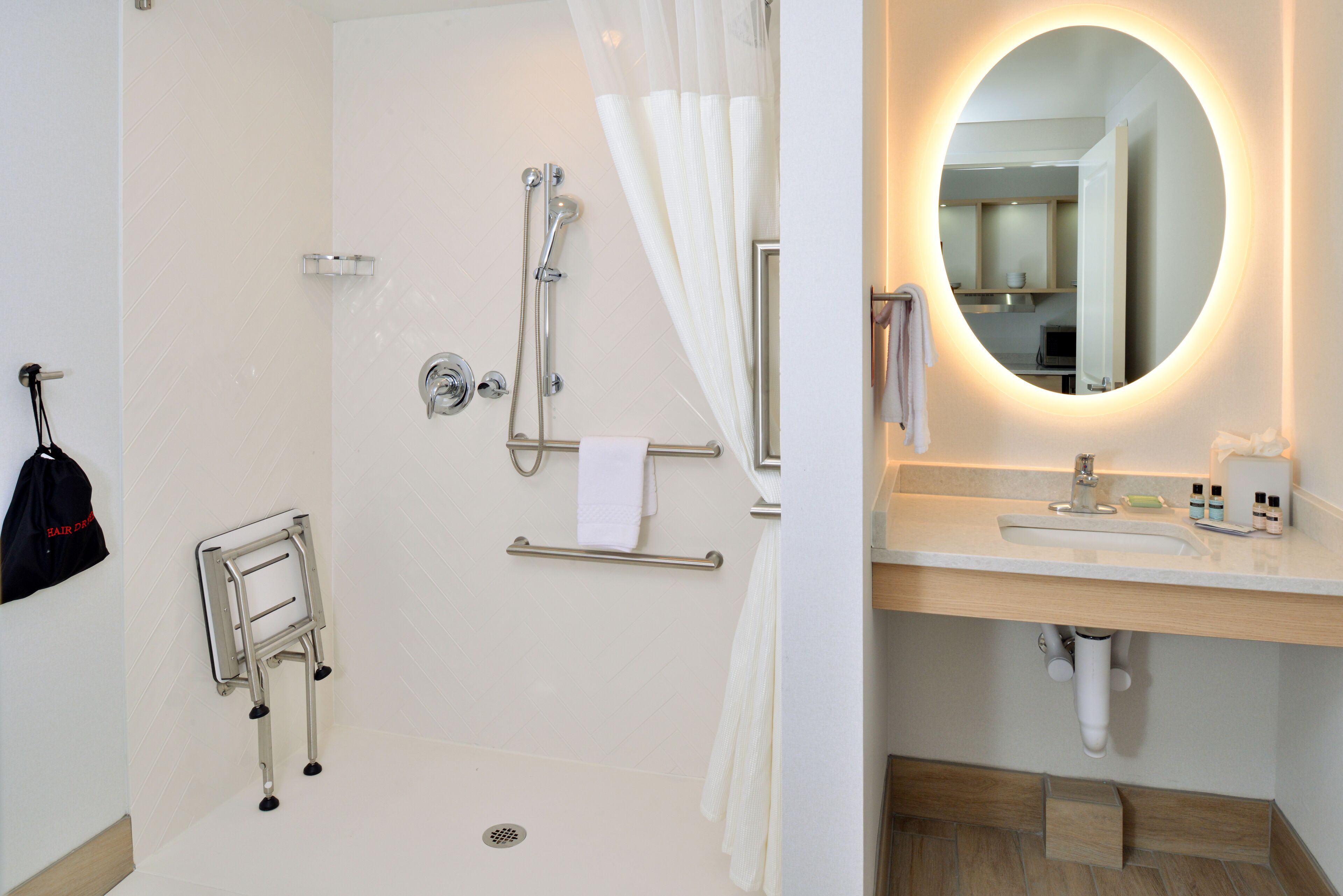 A bathroom with a shower, a toilet, a sink, and a mirror.