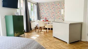 Ein Zimmer mit Bett, Schreibtisch, Stuhl, Kleiderschrank und Heizkörper.