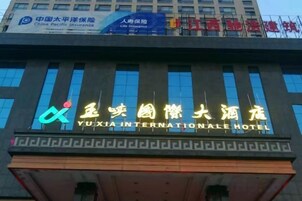 A hotel with a prominent sign for Yuxia International Hotel.