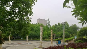 A park with a circular paved area, stone pillars, and a lamppost.