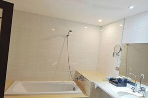 Ein modernes Badezimmer mit einer Badewanne, einem Waschbecken und einer Dusche.