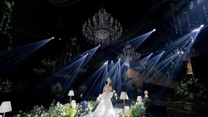 A wedding venue with a central aisle, floral arrangements, chandeliers, and ambient lighting. - Suopurui International Hotel (Linying)