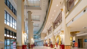 A spacious lobby with high ceilings, large windows, and a central chandelier. - Suopurui International Hotel (Linying)