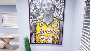 A room with a blue armchair, a small potted plant, and a framed artwork on the wall. - Poolside Palms  (West Palm Beach)