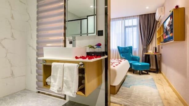 Une salle de bain équipée d’un lavabo, d’un miroir et d’un porte-serviettes.