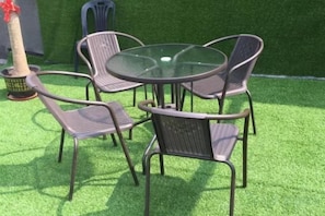 A round table with four chairs, surrounded by artificial green grass. - Moli Hotel (Guangzhou Yongqingfang Zhongshan 8th Road Subway Station) (Guangzhou)