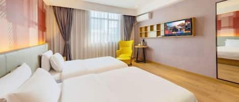 Une chambre d’hôtel avec deux lits, une chaise jaune, une télévision et une petite table.
