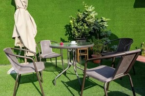 An outdoor seating area with a round table, four chairs, and a potted plant. - Moli Hotel (Guangzhou Yongqingfang Zhongshan 8th Road Subway Station) (Guangzhou)