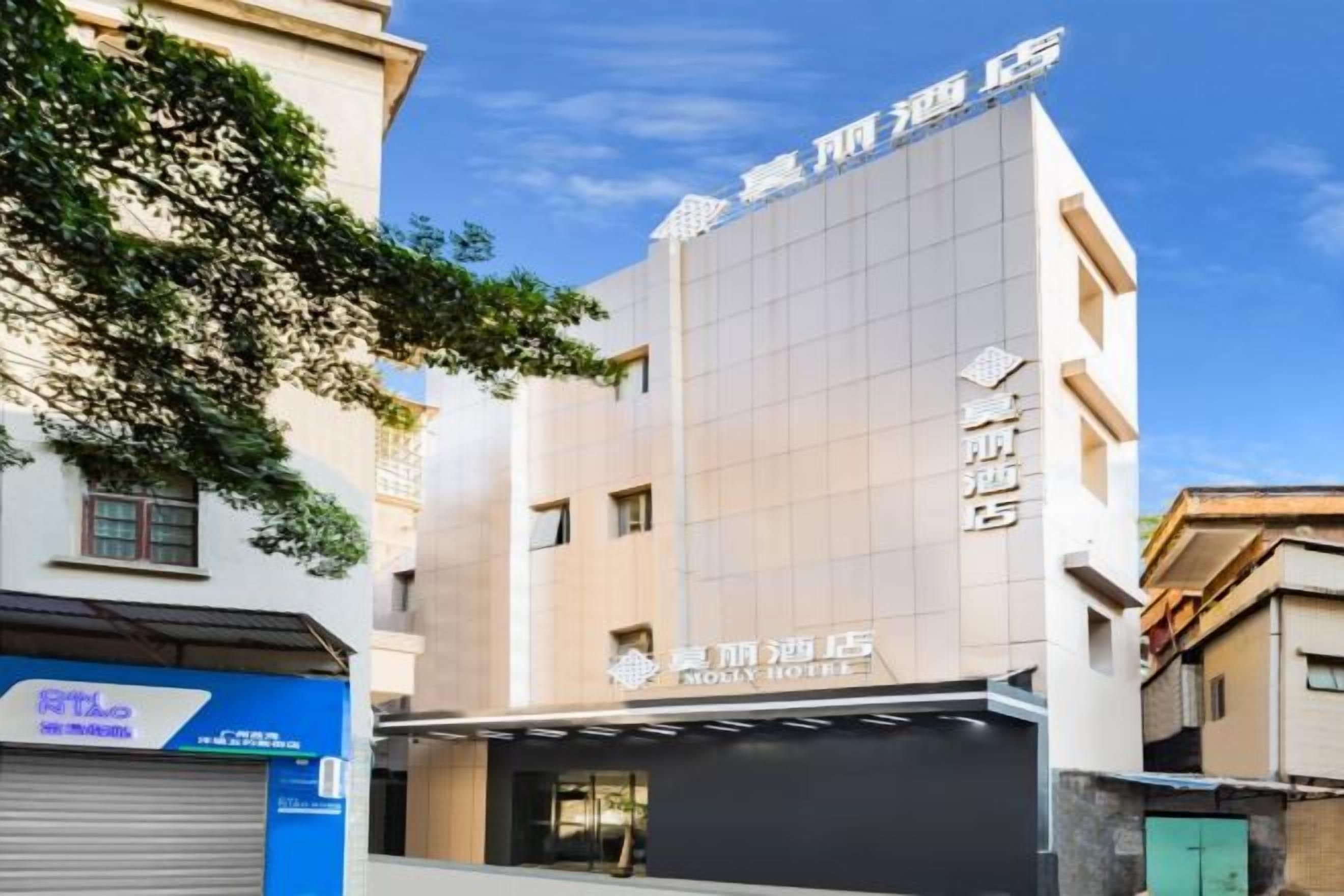 Un hotel con fachada moderna, entrada visible y señalización que indica que es un hotel.
