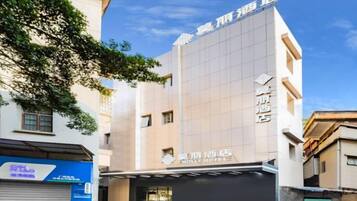 Un hotel con fachada moderna, entrada visible y señalización que indica que es un hotel.