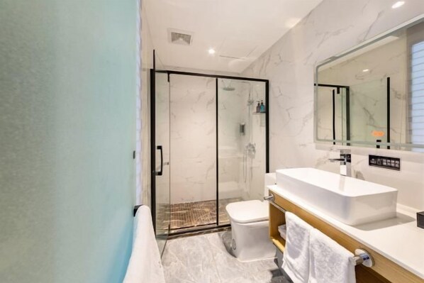A modern bathroom with a glass shower enclosure, a white sink, and a large mirror. - Moli Hotel (Guangzhou Yongqingfang Zhongshan 8th Road Subway Station) (Guangzhou)