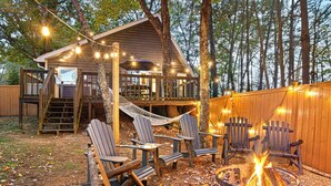 A wooden cabin with a deck, outdoor seating, and a fire pit. - Farmhouse Cabin Rustic Ridge: Hot Tub & Pets! (Blue Ridge)
