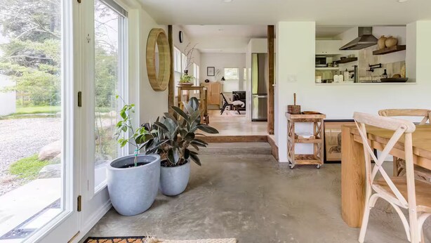 A spacious kitchen with a dining area, large windows, and potted plants. - Peaceful Light-Filled Guesthouse salt pool/sauna - 1 Hour From NYC (Pound Ridge)