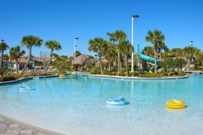 A clear blue pool with palm trees and a water slide. - Comfy, Spacious, Newly Decorated With Lovely Pool Near Disney! (Davenport)