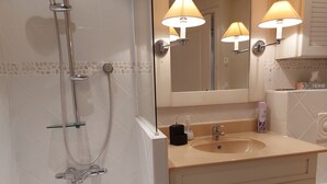 Un baño con bañera, lavamanos y espejo.