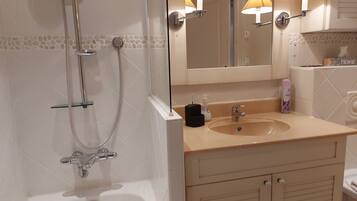 Een bad, een haardroger, handdoeken, toiletpapier