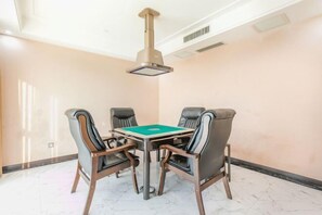 A conference room with a table and four chairs, a ceiling-mounted air conditioning unit, and a marble floor. - Tianzi International Hotel (Xiaogan)