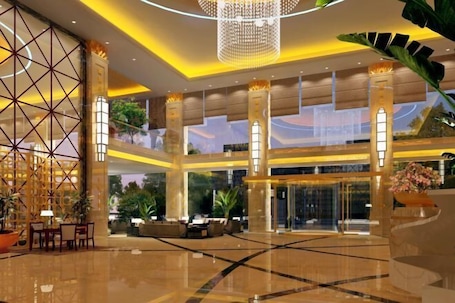 A spacious lobby with a high ceiling, large columns, and a central seating area.