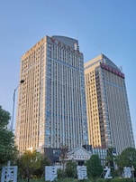 Ein Hochhaus mit einer gitterförmigen Fassade und Beschilderung oben.