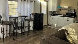 Un espacio habitable compacto con comedor, kitchenette y sofá.
