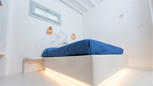 Una habitación moderna y minimalista con una cama empotrada e iluminación debajo de los armarios.