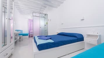 Un dormitorio moderno con una cama grande, una mesita de noche, un armario y una cabina de ducha de vidrio.