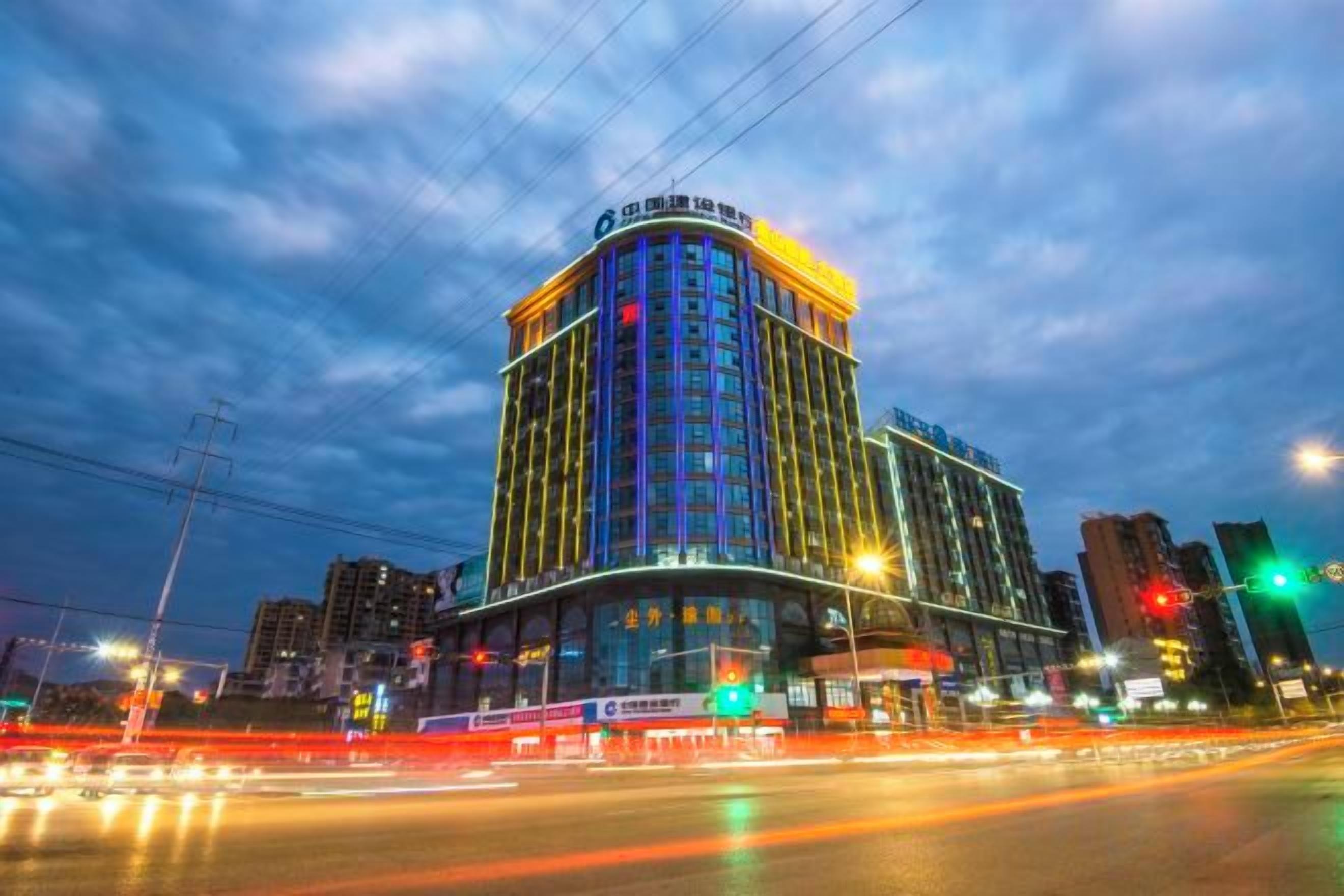 A multi-story hotel with a curved facade, large windows, and a prominent entrance.