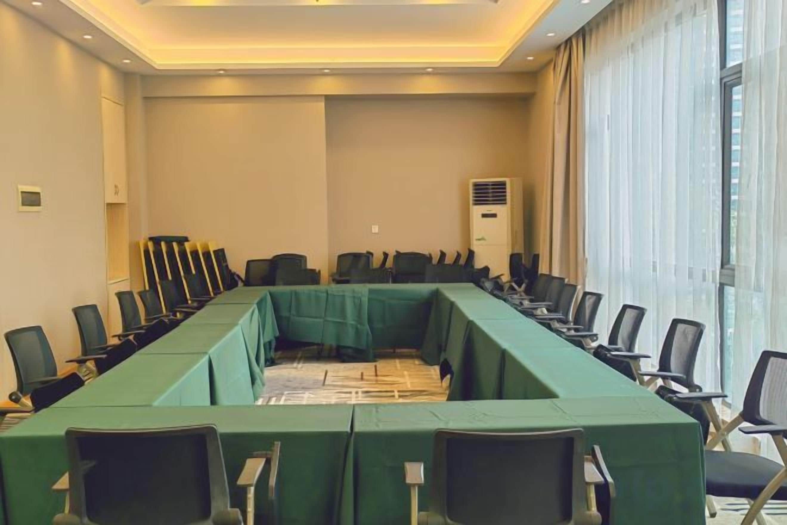 A conference room with a long table, chairs, and a large window.