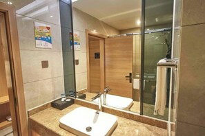 A modern bathroom with a large mirror, a sink, and a shower area. - Youyi Holiday Hotel (Foshan Lishui Jiaxuan Shopping Plaza Branch) (Foshan)