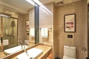 A modern bathroom with a large mirror, two sinks, a shower, and a toilet. - Youyi Holiday Hotel (Foshan Lishui Jiaxuan Shopping Plaza Branch) (Foshan)