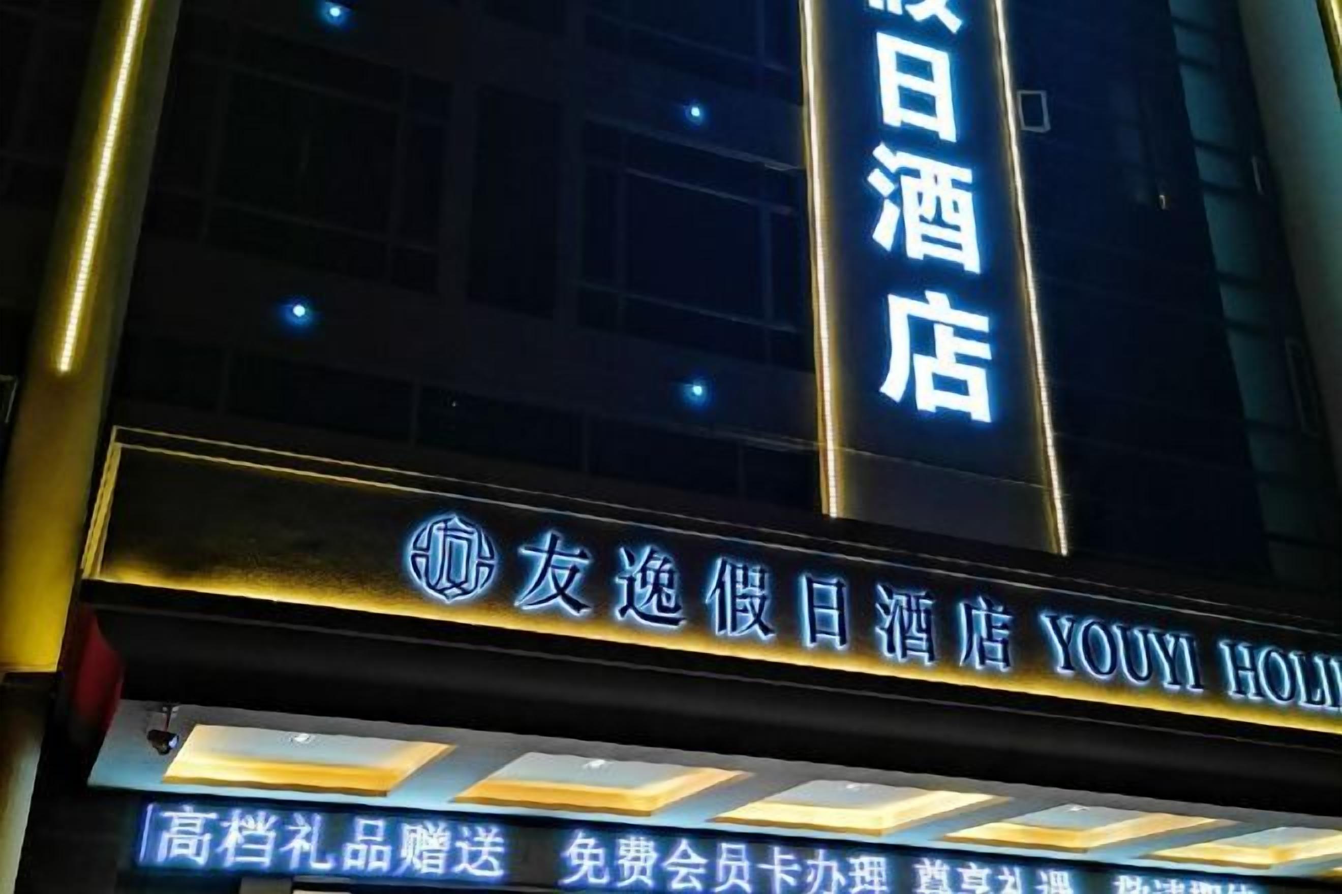 A hotel sign with illuminated text, indicating the hotel's name and services.