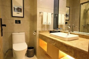 A modern bathroom with a toilet, sink, and shower. - Youyi Holiday Hotel (Foshan Lishui Jiaxuan Shopping Plaza Branch) (Foshan)