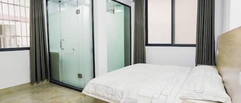 A bedroom with a bed, a wardrobe, and a window with curtains.