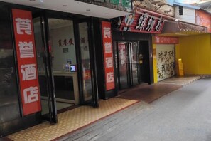 Entrada de un hotel con mostrador de recepción y una puerta cerrada.