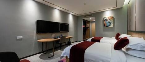 A hotel room with two beds, a desk, a chair, a flat-screen TV, and a painting on the wall.