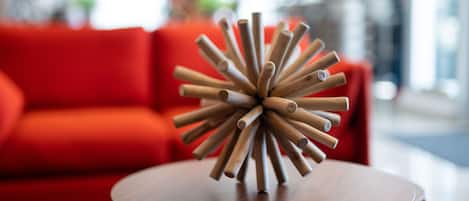 Una escultura de madera sobre una mesa redonda en una habitación con un sofá rojo.